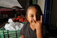Viernes 8 de julio. Un niño de escasos 6 años de edad juega y se divierte con la lente fotográfica mientras que sus padres se dedican a la distribución del fruto del Rambután en la Central de Abastos de la ciudad de Tuxtla Gutiérrez. Este fruto es sembrad