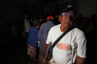 Viernes 8 de julio. Adultos de la tercera edad reciben despensas durante las madrugadas de lluvia en el Banco de Alimentos de la Central de Abastos de la ciudad de Tuxtla Gutiérrez, este banco de alientos  acepta alimentos rescatados de las bodegas de la 