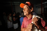 Viernes 8 de julio. Adultos de la tercera edad reciben despensas durante las madrugadas de lluvia en el Banco de Alimentos de la Central de Abastos de la ciudad de Tuxtla Gutiérrez, este banco de alientos  acepta alimentos rescatados de las bodegas de la 