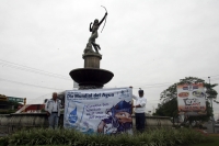 Un ciclista interrumpe a los trabajadores quienes reparten cubetas durante las celebraciones del Día Mundial del Agua para exigirles que sea regularizado el servicio de agua potable en el oriente de esta ciudad.