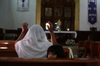 20240226. Berriozábal. Una mujer desesperada ora en el templo de San Estaban por los constantes mensajes de alerta de violencia después de la desaparición y ejecución de elementos de la policía municipal.