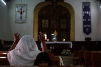 20240226. Berriozábal. Una mujer desesperada ora en el templo de San Estaban por los constantes mensajes de alerta de violencia después de la desaparición y ejecución de elementos de la policía municipal.