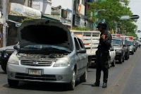 Especial / El Calor / 14 fotos / Un vehiculo descompuesto detiene el trafico en la avenida central, el calor es intenso mientras que un policía intenta auxiliar al conductor; la gente compra helados y aguas frescas mientras transcurre el tiempo. Los niños