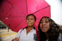 Varias jóvenes se preparan para el calor o la lluvia llevando sombrillas para estos días