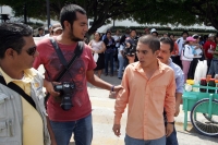 Martes 12 de octubre. Un joven estudiante intenta evitar que los reporteros graficos hagan tomas periodísticas de la marcha-bloqueo conmemorativo del 12 de octubre, esta mañana en la avenida central.