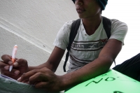 Jueves 27 de noviembre del 2014. Tuxtla Gutiérrez. Suturado de los labios escribe sus demandas a favor de los niños de la calle, sentado en las gradas de la estatua de Joaquín Miguel Gutiérrez en la entrada del ayuntamiento de la ciudad.