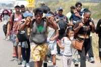 20240410. Tuxtla. Caravana de migrantes caminan bajo el sol del mediodía entre las ciudades de Berriozábal y Cintalapa.