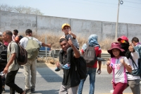 20240410. Tuxtla. Caravana de migrantes caminan bajo el sol del mediodía entre las ciudades de Berriozábal y Cintalapa.