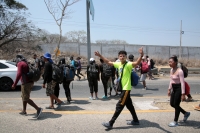 20240410. Tuxtla. Caravana de migrantes caminan bajo el sol del mediodía entre las ciudades de Berriozábal y Cintalapa.