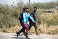 20240410. Tuxtla. Caravana de migrantes caminan bajo el sol del mediodía entre las ciudades de Berriozábal y Cintalapa.