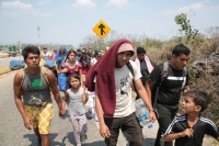 20240410. Tuxtla. Caravana de migrantes caminan bajo el sol del mediodía entre las ciudades de Berriozábal y Cintalapa.