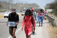 20240410. Tuxtla. Caravana de migrantes caminan bajo el sol del mediodía entre las ciudades de Berriozábal y Cintalapa.