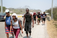 20240410. Tuxtla. Caravana de migrantes caminan bajo el sol del mediodía entre las ciudades de Berriozábal y Cintalapa.