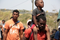 20240410. Tuxtla. Caravana de migrantes caminan bajo el sol del mediodía entre las ciudades de Berriozábal y Cintalapa.